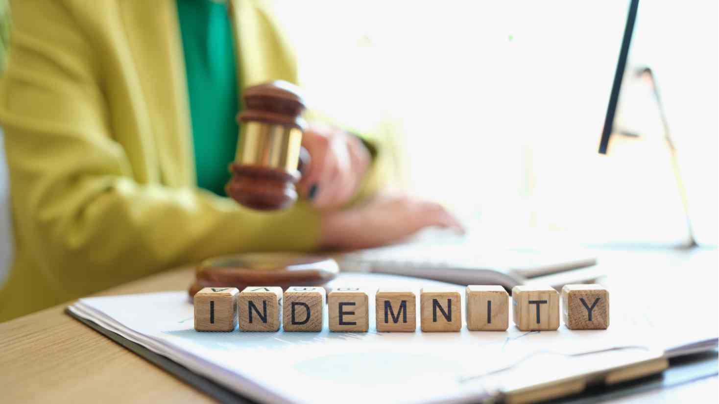 Image of someone holding a judges gabble with indeminty written out in letter blocks for the blog What is an Indemnity Claim and How to Decrease Them